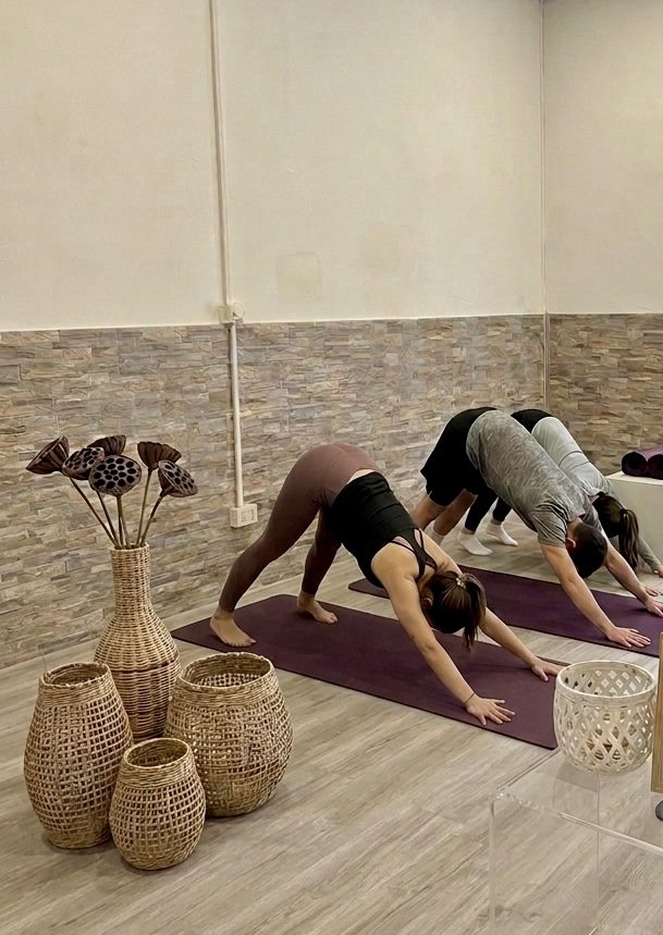 Lezione di yoga da Infinity Yoga Boutique Studio, allievi in posizione del cane a testa in giù